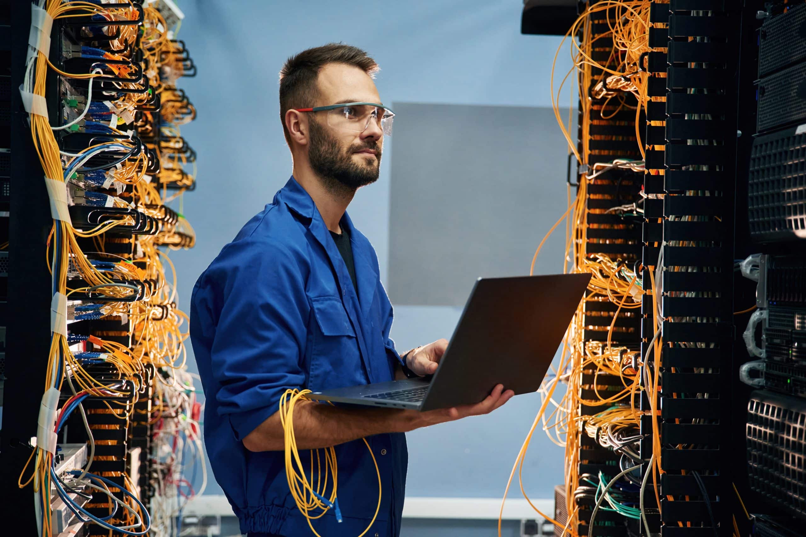 Person holding laptop in server room